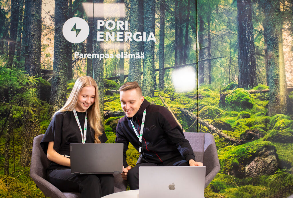Kaksi henkilöä työskentelee kannettavan tietokoneen äärellä Pori Energian toimistotiloissa
