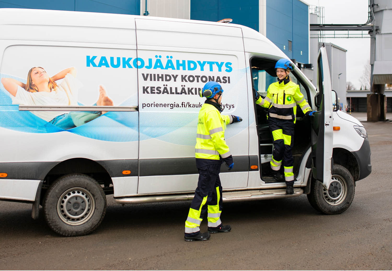 Kaksi Pori Energian työvarusteisiin pukeutunutta henkilöä seisoo huoltoauton läheisyydessä Aittaluodon voimalaitoksen ulkoympäristössä